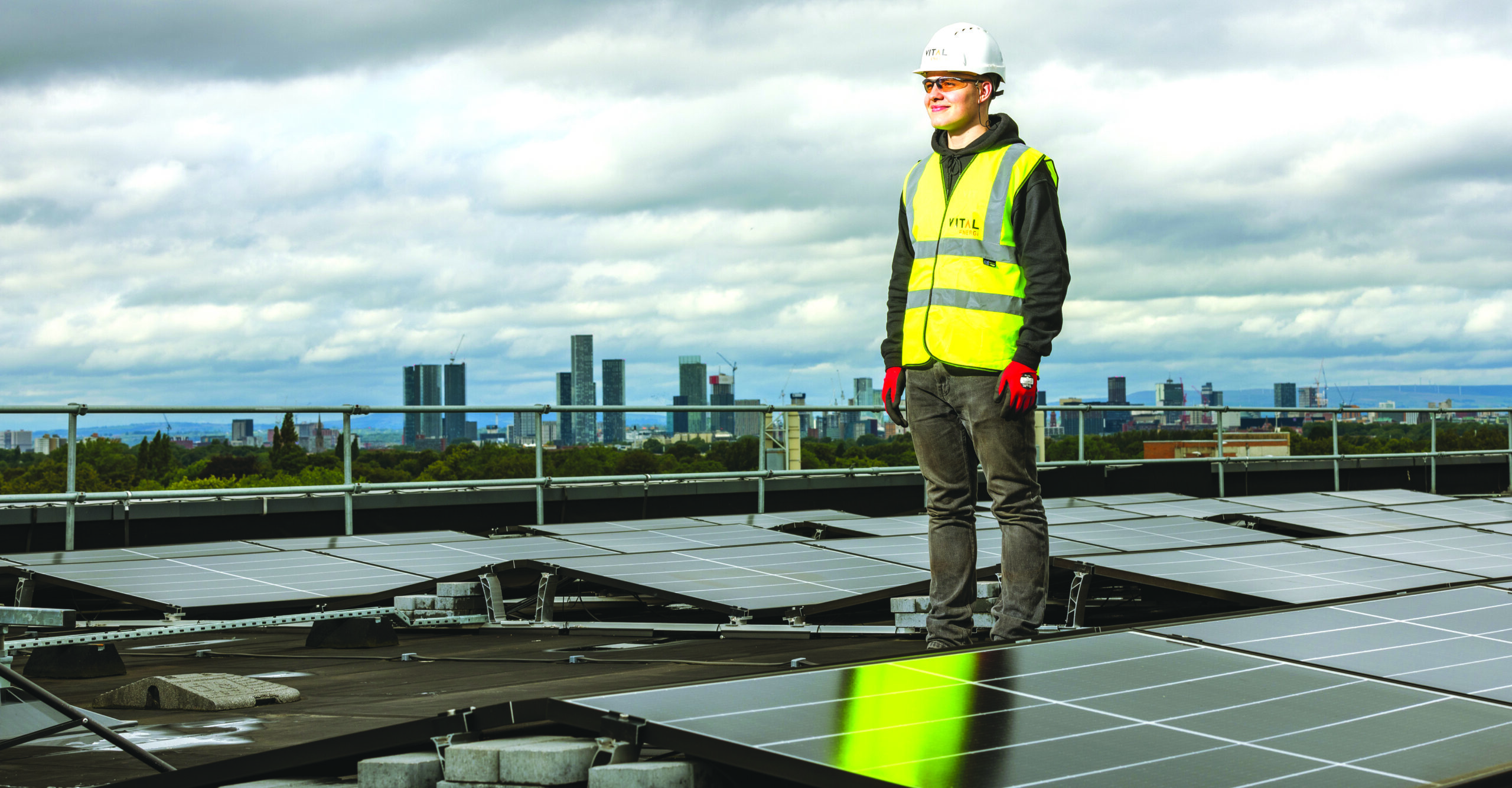 Worker inspecting a commercial rooftop solar panel installation.