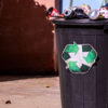 Recycling bin filled with recyclable materials at the curb