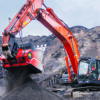 Excavator with processing attachment handling material