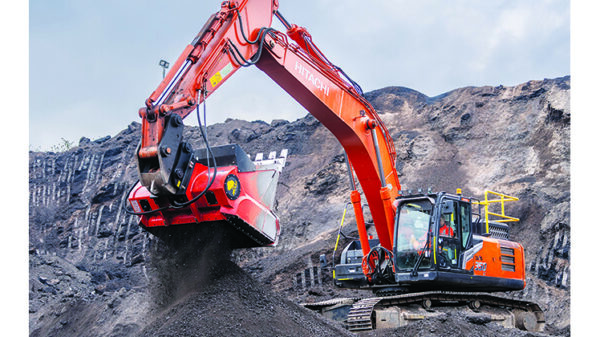 Excavator with processing attachment handling material