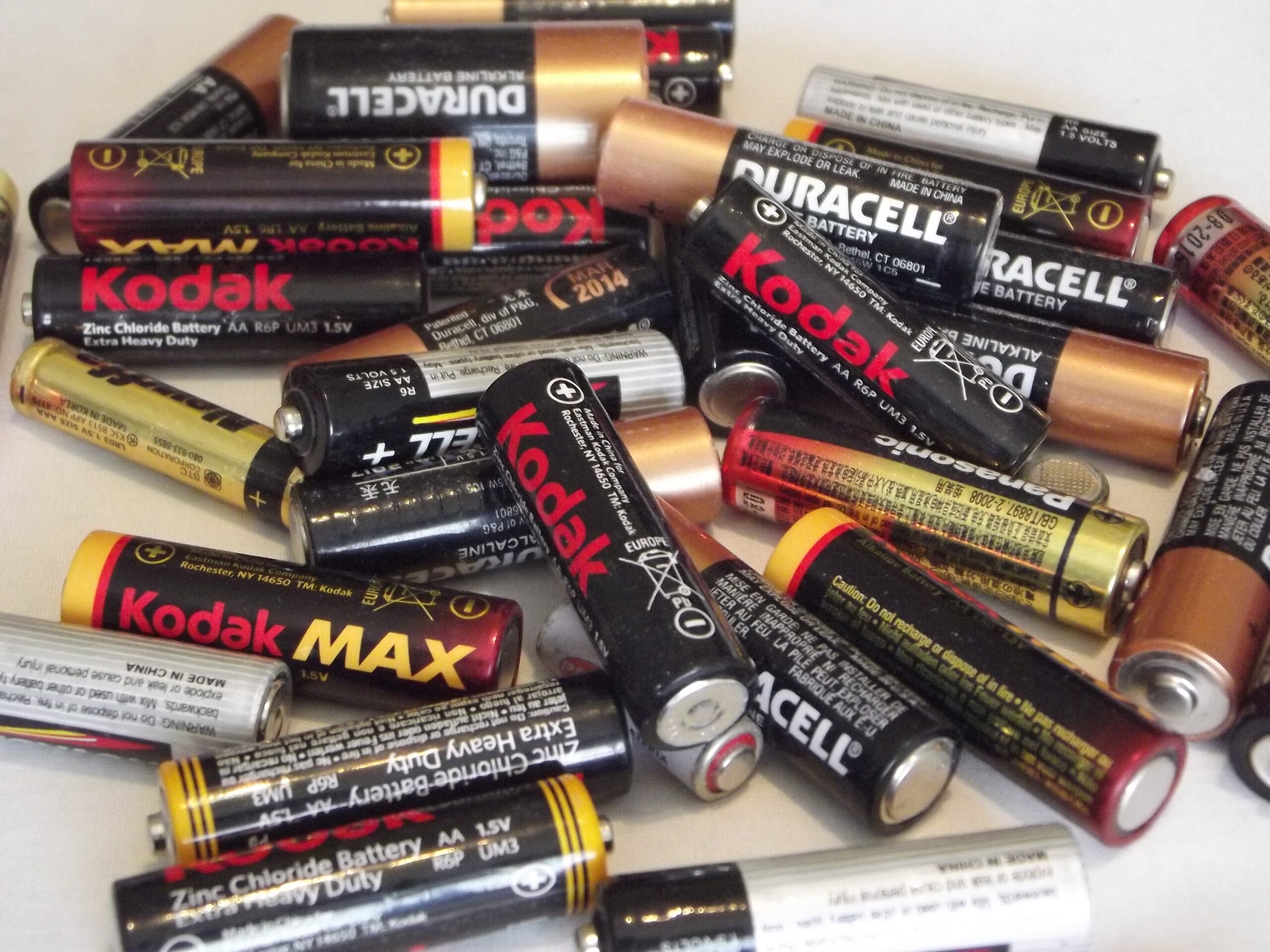 Collection of used household batteries including AA and AAA alkaline batteries for recycling or disposal