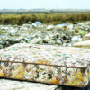 Discarded mattresses awaiting recycling at a mattress waste recovery facility
