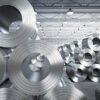 Steel coils stored in a manufacturing facility representing steel production, processing and industrial supply chains