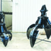 Two heavy-duty orange-peel grapples used for handling scrap metal and other bulk recycling materials