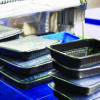 Plastic food packaging trays on industrial processing equipment for packaging production
