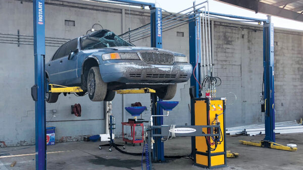 Vehicle on lift with automotive fluid removal equipment